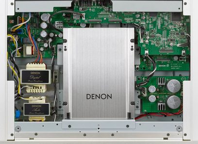 Wnętrze odtwarzacza CD Denon DCD-2500NE w kolorze srebrnym, pokazujące zielone obwody elektroniczne i komponenty na metalowej ramie