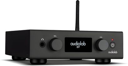 Audiolab D7 melna matēta metāla audio DAC pārveidotājs, skatāms nedaudz no sāniem, kompakts korpuss ar centrālo ekrānu, diviem lieliem grozāmiem regulatoriem, austiņu ligzdu, ieslēgšanas pogu un aizmugurējo antenu