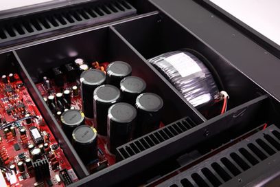 Stereo hi-fi forstærker Advance Paris X-i1100, set ovenfra indvendigt, røde og sorte elektroniske kredsløb, store sølvfarvede kondensatorer