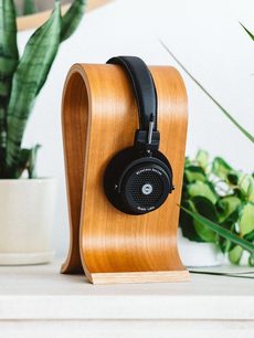 Grado GW100 hovedtelefoner med lys træstruktur, sorte ørepuder, sort polstret hovedbøjle, stillet lodret på træsokkel