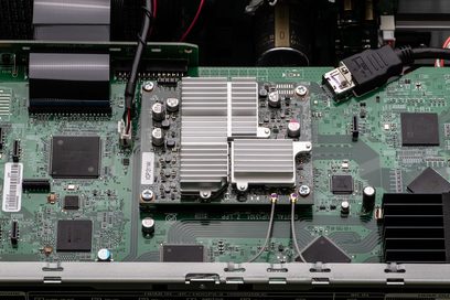 Carte électronique verte avec composants électroniques, dissipateur thermique en aluminium et connecteurs, vue de dessus rapprochée