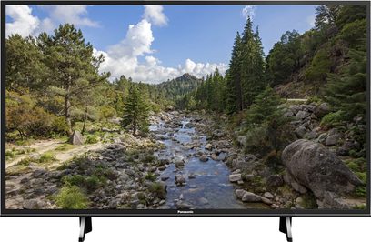Panasonic TX-43FX600 tv der viser et bjerglandskab med flod, nåleskov og skyet himmel