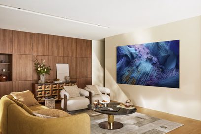 Großer schwarzer Flachbildfernseher mit ultrafinem Metallrahmen, aus linkem Winkel gesehen, an der Wand eines modernen Wohnzimmers montiert und mit einem abstrakten blau-violetten Bild auf dem Display