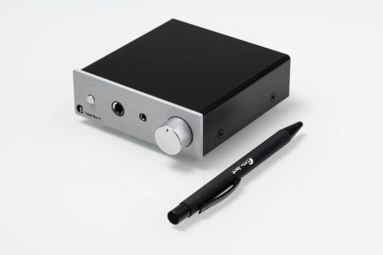 Pro-Ject Head Box E ausinių stiprintuvas juodos ir sidabrinės spalvos su garsumo reguliavimo rankenėle, matomas trijų ketvirčių kampu
