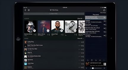 Černý tablet iPad při pohledu zepředu, obrazovka TIDAL v režimu na šířku s alby a hudebním playlistem