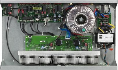 Indvendigt syn af en åben sort Micromega IA60 stereo hi-fi-forstærker, der viser de elektroniske kredsløb og en stor cirkulær køleflade