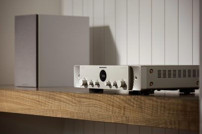 Marantz Stereo 70 gümüş renkli stereo hi-fi amplifikatör, ön görünüm, ahşap bir raf üzerinde duruyor, açık gri kasasıyla