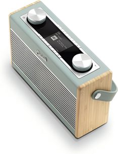 Radio przenośne Roberts Rambler Max w kolorze niebiesko-błękitnym, widok z trzech czwartych z góry, obudowa z pastelowego plastiku z frontem z metalową kratką poziomą, boczne panele z jasnego drewna, czarny wyświetlacz i rząd przycisków otoczonych dwoma dużymi srebrnymi pokrętłami, pasujący pasek boczny.