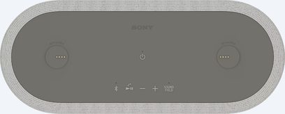 Bezprzewodowy głośnik Sony HT-AX7, widok z góry, owalny kształt, szara powierzchnia, centralnie umieszczone przyciski dotykowe, teksturowana krawędź