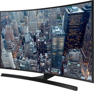 Samsung UE48JU6640 buet TV viser et natligt luftfoto af en tætbefolket by med mange oplyste skyskrabere