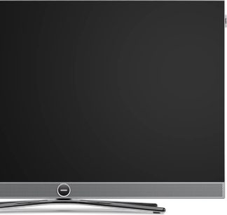 Telewizor Loewe Vega 43 czarny, widok z przodu, cienka srebrna ramka, perforowana dolna maskownica i centralna chromowana podstawa