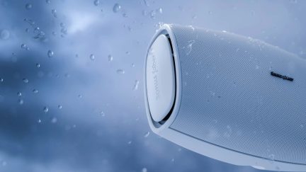 Weiße kabellose Sonus faber Lautsprecherbox mit perforiertem Gitter, Seitenansicht mit Wassertropfen
