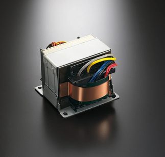Elektrisk transformer med farvede kobbertråde viklet rundt en rektangulær metallegekerne på ensfarvet grå baggrund