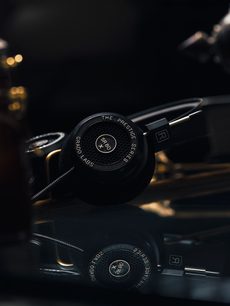 Åben Grado SR80x hi-fi hovedtelefon i sort, tæt på front- og profilvisning, placeret på en mørk reflekterende overflade