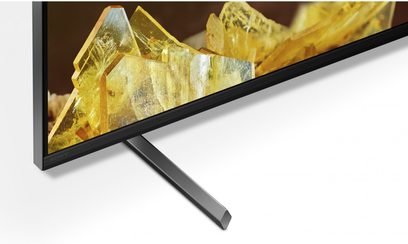Sony TV XR85X90L, set fra siden, sort skærm, skråt metalstativ, billede af gule krystaller vist
