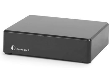 Phono priešstiprintuvas Record Box E juodas, kompaktiškas stačiakampis korpusas, lygi paviršiaus tekstūra, priekyje baltas logotipas ir tekstas, perspektyvinis vaizdas.