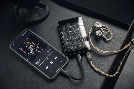 Conjunto áudio portátil smartphone leitor conectado a DAC USB preto e auriculares intra-auriculares em metal com cabo entrançado dourado