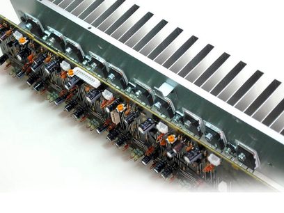Nærbillede af indersiden af en sort Marantz NR1604-forstærker, der viser flere printplader med elektroniske komponenter på række