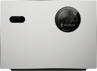 Valerion StreamMaster Plus 2 matte white plastic projector, front view, rectangular front panel with large black circular lens featuring the logo on the right and a small black oval sensor window on the left, discreet black foot at the bottom
