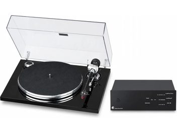 Schwarzer Plattenspieler mit hochgeklappter transparenter Abdeckhaube und Tonarm, dazu der Vorverstärker Phono Box S3 B