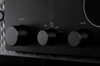 Sorte drejeknopper med indskrifterne "MM", "MC", "LOW", "MID", "HIGH" på den sorte metalkontrolpanel på en sort Marantz Model 30 hi-fi stereoforstærker, tæt forfra