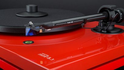 Rød Music Hall MMF 5.3 LE pladespiller med sort tonarm, pickup og modvægt på en blank rød plade