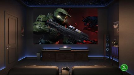 Sala de cine en casa gaming con proyector de ultracorta distancia y Xbox, gran pantalla futurista de Halo