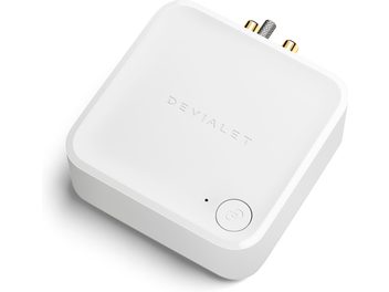 DEVIALET ARCH baltā krāsā, skats no augšpuses, noapaļota kvadrātveida forma, logotips, zelta krāsas pogas, austiņu ligzda