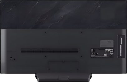 Τηλεόραση υψηλής ευκρίνειας LG OLED48C5, ματ μαύρο πλαστικό πίσω κάλυμμα με μεγάλη κεντρική γρίλια αερισμού, θύρες HDMI, USB και LAN ευθυγραμμισμένες στη δεξιά πλευρά, προεξέχουσα ορθογώνια βάση στο κάτω μέρος, πίσω όψη