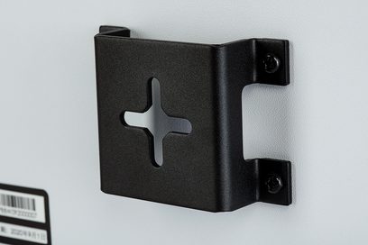 Rektangulär svart högtalare med metallkors på framsidan och två fästskruvar på högra sidan