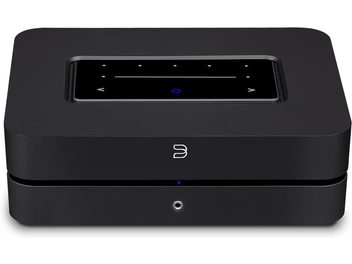 BlueSound Powernode sort hi-fi stereforstærker, set forfra. Rektangulært sort kabinet med blå LED-skærm og knapper