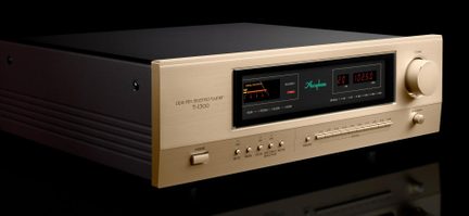 Stereo hi-fi tuner v kartáčovaném hliníku šampaňského odstínu s černým tělem, displejem s červenými číslicemi a VU metrem, velký knoflík vpravo