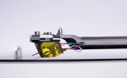 Rega Aphelion 2 MC vinylplade-pickup, nærbillede fra siden, sort kabinet, gul diamantspids, farvede kabler