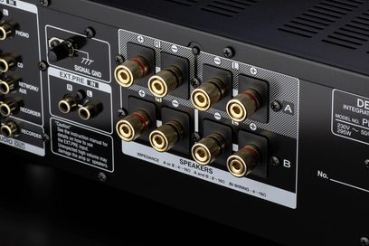 Zadní panel audio zesilovače Denon PMA-1700NE s RCA konektory, svorkami pro reproduktory a přepínačem impedance