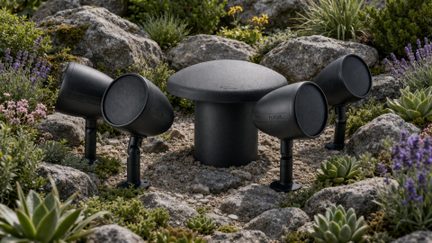 Sistema audio da giardino Focal nero con quattro altoparlanti esterni e subwoofer centrale tra le rocce