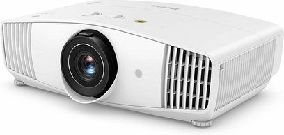 Benq W5700S baltasis projektorius, vaizdas iš priekio, dešinėje pusėje išsikišęs objektyvas, šoninės ventiliacijos grotelės