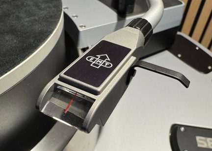 EMT cartridge and headshell in silver metal, transparent window with red marker, lift lever, oblique close-up