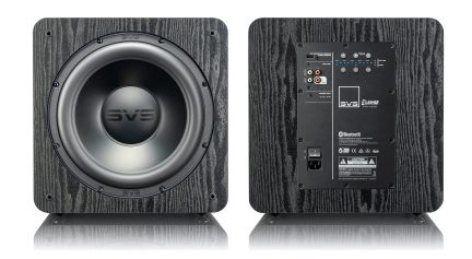 Subwoofer SVS SB-1000 Pro nero visto frontalmente con altoparlante argentato e pannello di controllo, su sfondo in legno scuro
