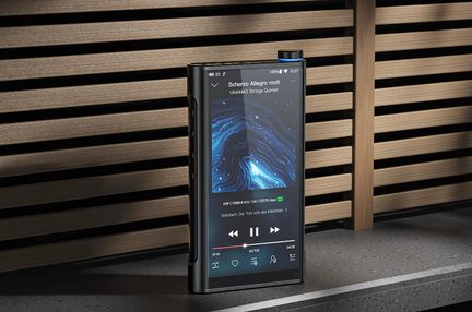 Sort, digital musikafspiller i metal, set fra trekvart front, med stor aktiv touchskærm, blåtonet cirkulær drejeknap øverst til højre og tre sideknapper