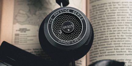 Musta kuulokekuori lähikuvassa, pyöreä metalliverkko, tekstit SR325x Prestige Series Grado Labs