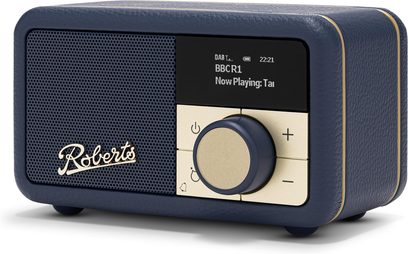 Trekvartersvisning af Roberts Revival Petite 2 bordradio i mørkeblå, kornet kunstlæder, perforeret gitterfront med gyldent logo, sort digitalt display, fire kvadratiske gyldne knapper omkring en stor gylden drejeknap, kanter med tynde metalstribninger