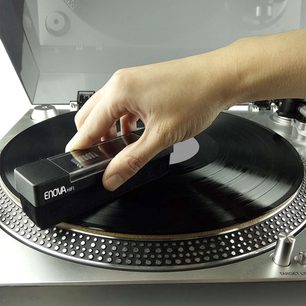 Kartáč na vinyl Enova HIFI BVA 10 černý na stříbrném gramofonu, detailní pohled shora na ruku držící kartáč