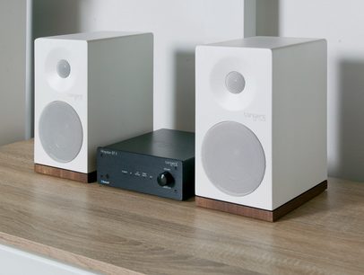 Dva bílé obdélníkové reproduktory Tangent s černou kruhovou mřížkou a černý stereo hi-fi zesilovač Tangent Ampster BT II