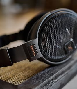 Casque hifi ouvert Sennheiser HD 660S2 noir, vue rapprochée de profil droit sur fond bois, logo argenté "HD 660S2" sur l'arceau