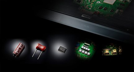 Black soundbar, green electronic circuits, red and yellow capacitors, close-up front view