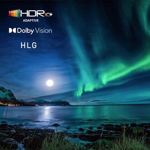 Nordlys i grønne farver oplyser nattehimlen over et klippefyldt kystlandskab, HDR10+ Dolby Vision HLG-logoer