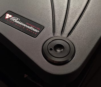 Černý kruhový reproduktor zepředu s logem "Bassocontinuo" a textem "Handmade in Italy Fine Audio Racks" na kovovém štítku