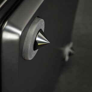 Dynamo 12 subwoofer i sort lak, skinnende konisk metalspids monteret på en mat cirkulær base, nærbillede fra siden