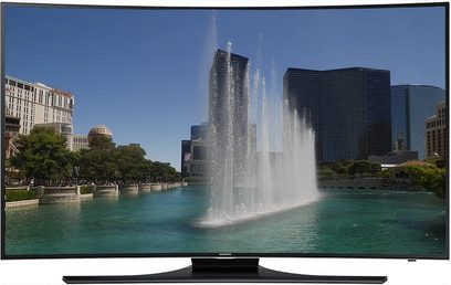 Zakřivený televizor Samsung UE48H6800, zapnutá obrazovka zobrazující fontány před budovami, umístěný na černém stojanu