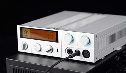 Hõbedase metallkorpusega heliseade, vaade kolmest veerandist eest, oranž ekraan, nupud, kõrvaklapipesad (jack ja XLR), USB‑C port